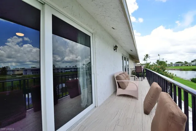 a balcony with wooden floor and outdoor seating