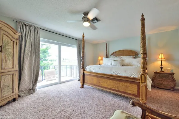 a bedroom with a bed window and a chandelier