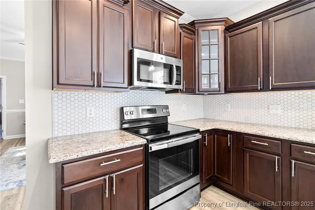 a kitchen with granite countertop a stove microwave and sink