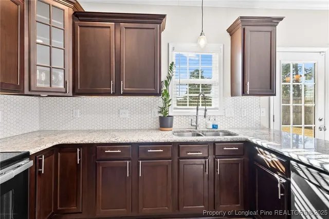 a kitchen with granite countertop a sink stainless steel appliances and cabinets