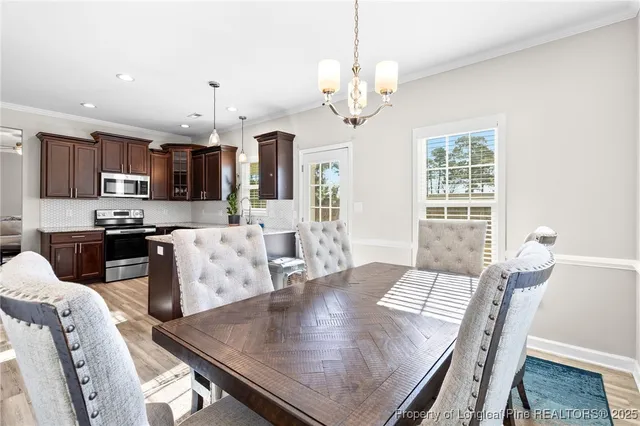 a view of a dining room with furniture a chandelier and wooden floor