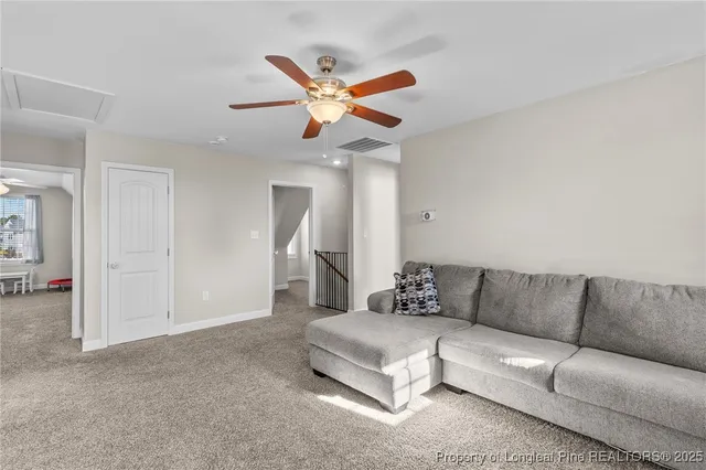 a living room with furniture and a ceiling fan
