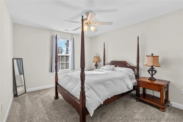 a bedroom with a bed a chandelier and mirror