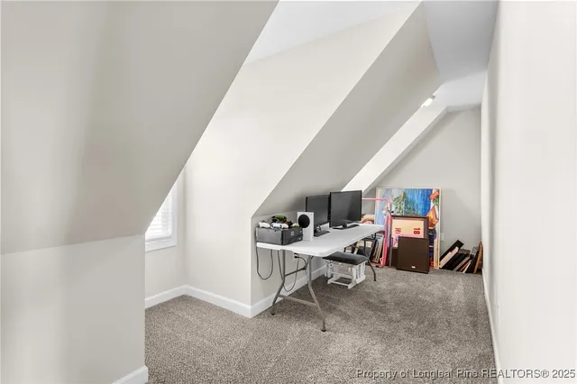 a view of a workspace with furniture and a hallway