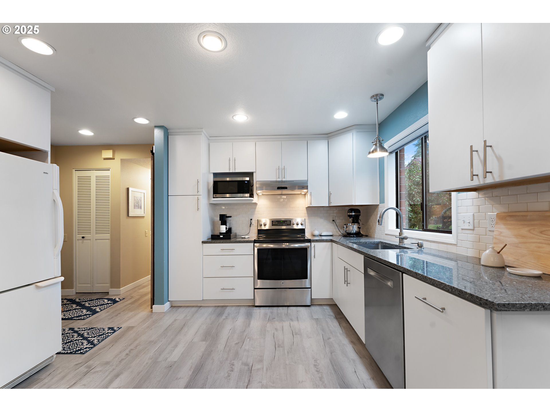 15514 Southwest 114th Court, Unit 61 Tigard, OR 97224 - Photo 13 of 35 a kitchen with stainless steel appliances granite countertop a refrigerator a sink dishwasher a stove and white countertops with wooden floor