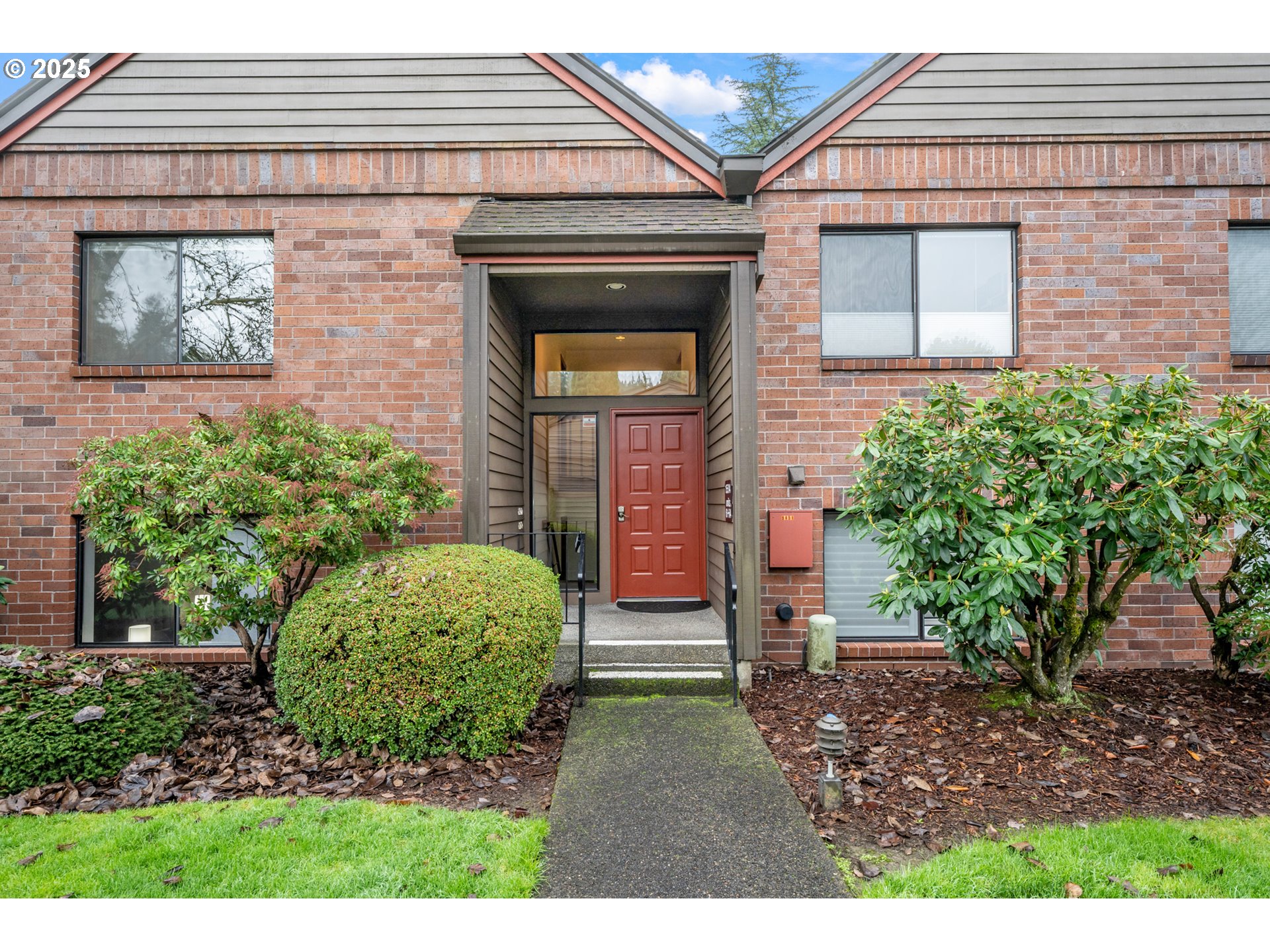 15514 Southwest 114th Court, Unit 61 Tigard, OR 97224 - Photo 2 of 35 a view of a house with brick walls and a yard with plants