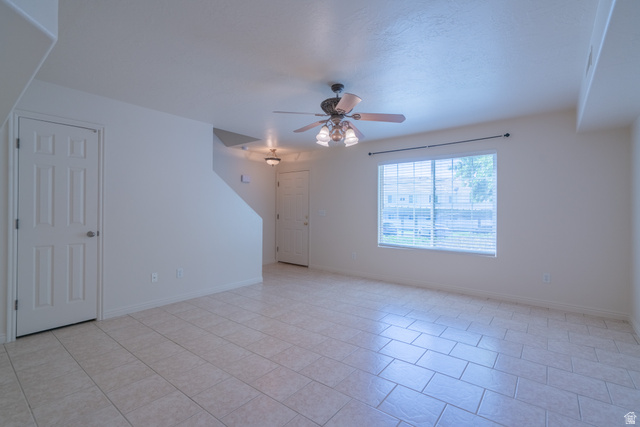 1735 West 540 North, Unit 1805 St. George, UT 84770 - Photo 15 of 64 Spacious living area featuring light-toned tile flooring, a large window with horizontal blinds, and a ceiling fan with integrated lighting