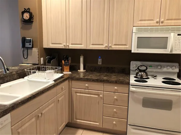 a kitchen with granite countertop white cabinets and white appliances