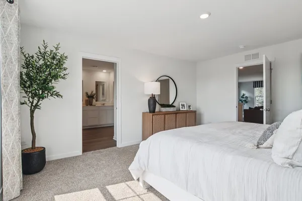 a bedroom with a bed and a potted plant