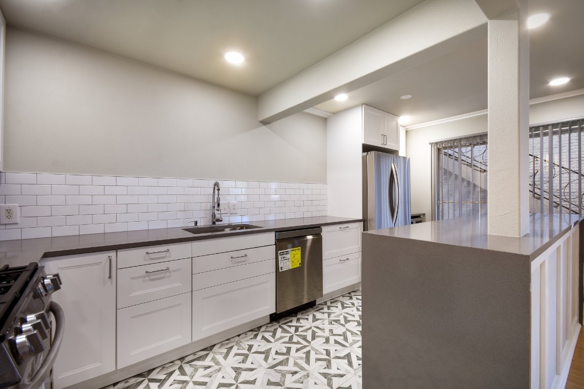 a kitchen with stainless steel appliances a sink and a refrigerator