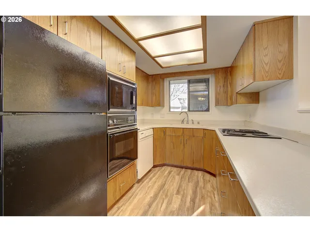 a kitchen with granite countertop a refrigerator stove and sink