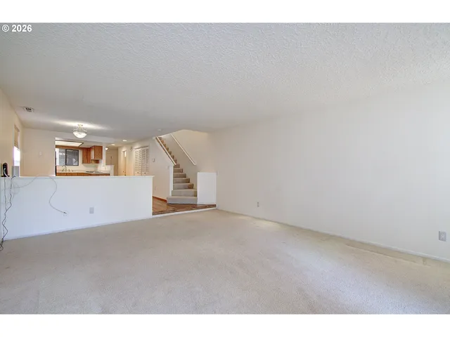 a view of a big room with wooden floor and windows