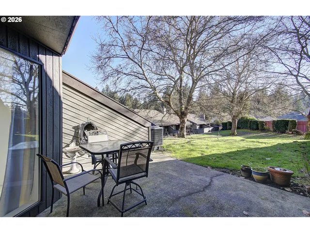 a backyard of a house with table and chairs
