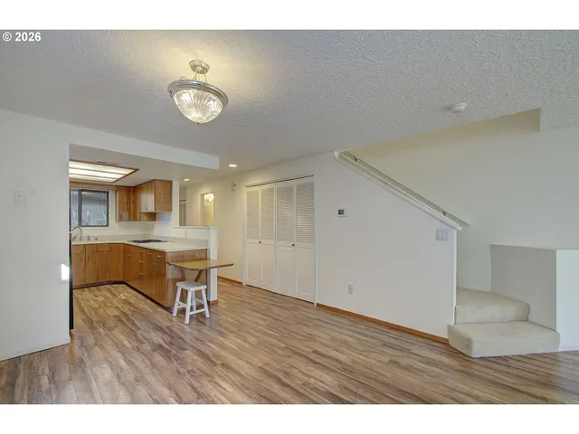 a view of workspace and kitchen with furniture wooden floor and window