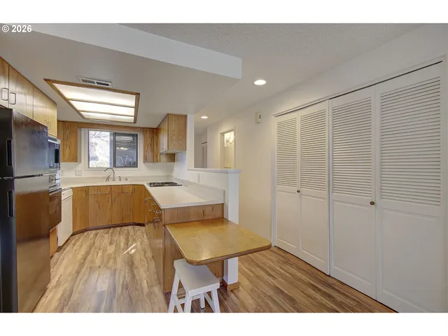 a view of a living room and kitchen view with wooden floor