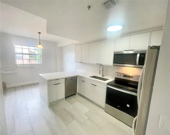a kitchen with stainless steel appliances a stove a sink and a microwave