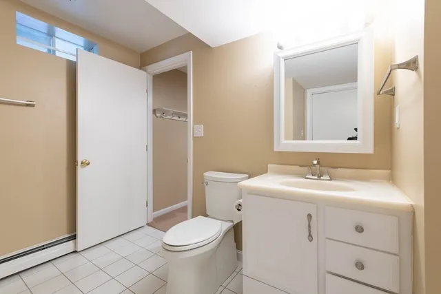 a bathroom with a toilet a sink a vanity and mirror