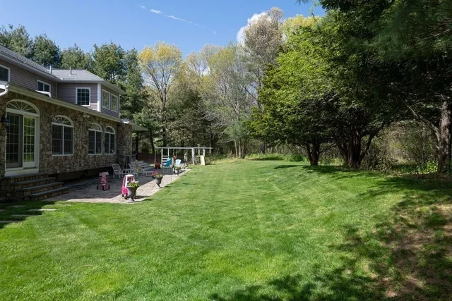 a view of a house with a backyard and a tree