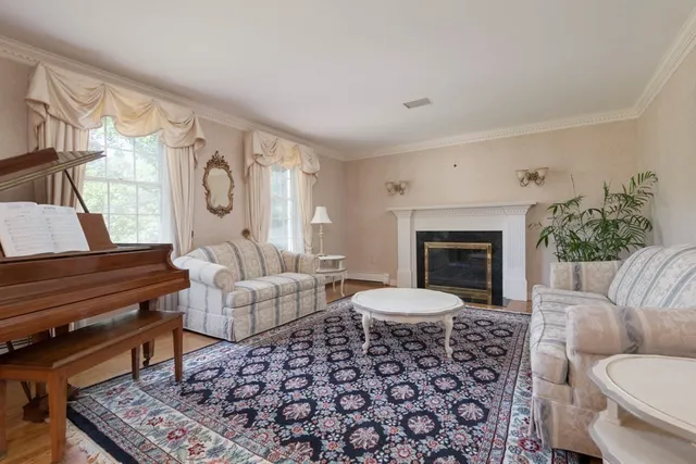 a living room with furniture a fireplace and a large window