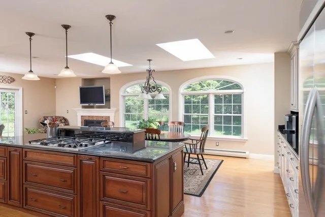 a kitchen with stainless steel appliances granite countertop a stove a sink and a wooden floors