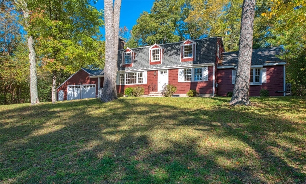 a view of a house with a big yard and large trees