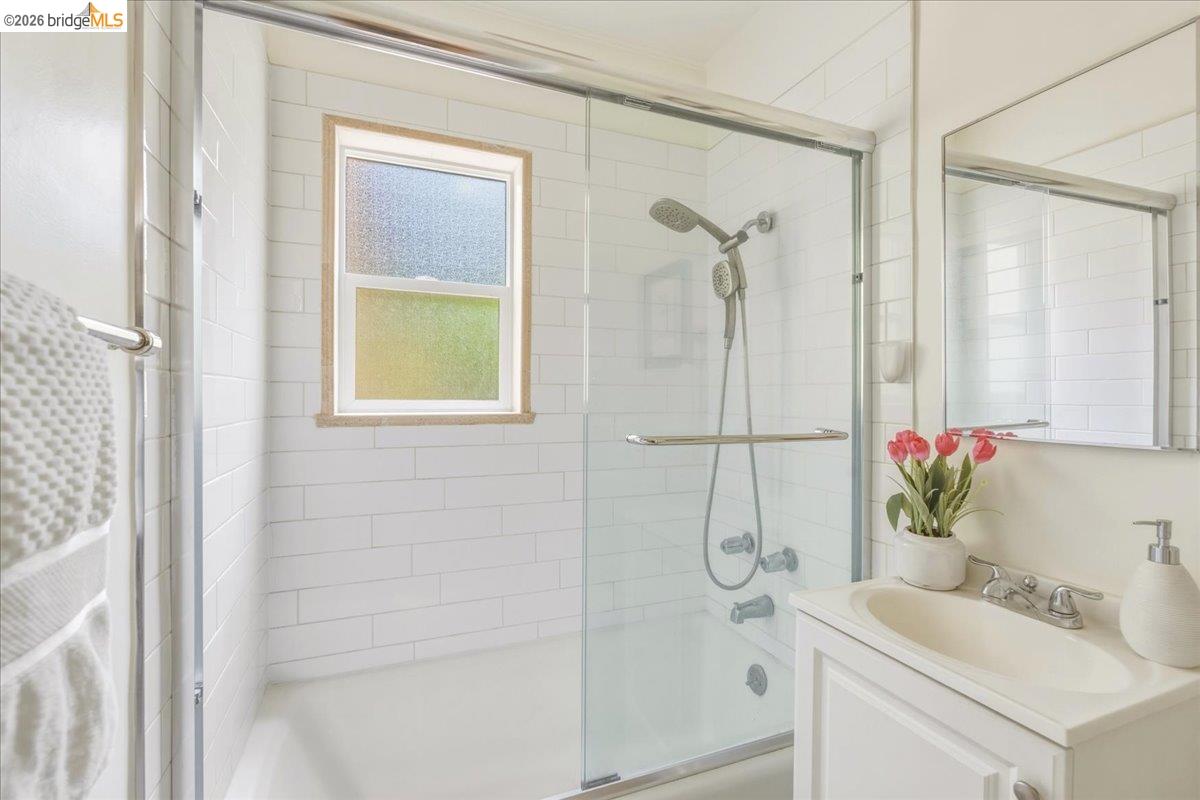 2403 Cedar Street Berkeley, CA 94708 - Photo 15 of 33 Bathroom featuring a tub/shower combination with white subway tile surround and a sliding glass enclosure