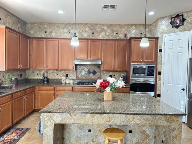 a kitchen with stainless steel appliances granite countertop a sink a stove and cabinets