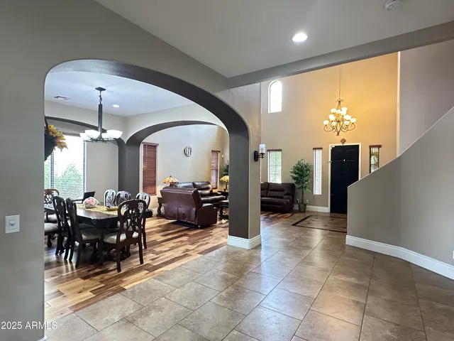 a living room with furniture a chandelier and a large window