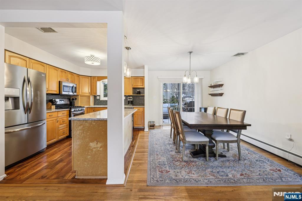 4 Birch Road Ringwood, NJ 07456 - Photo 15 of 41 a view of a dining room and livingroom with furniture wooden floor a rug a flat screen tv