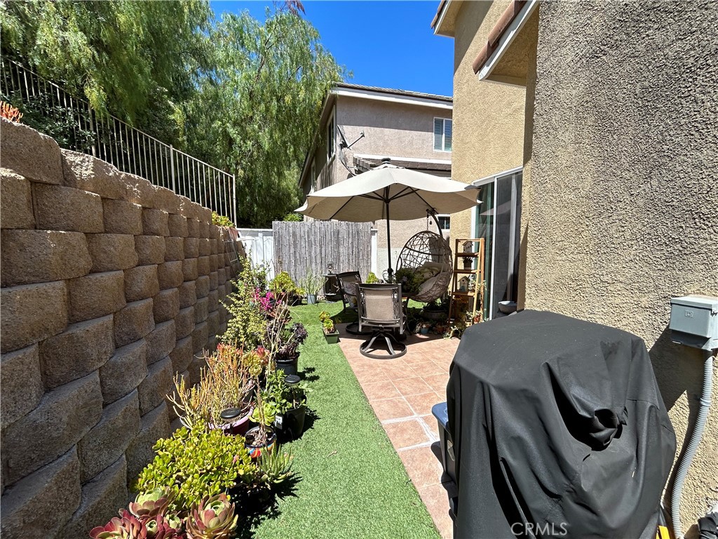 24702 Montevista Circle Valencia, CA 91354 - Photo 21 of 25 a view of a patio with lawn chairs under an umbrella