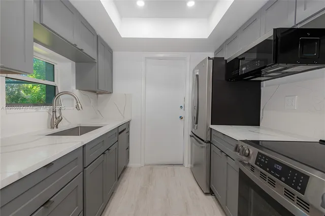 a kitchen with stainless steel appliances a sink stove and refrigerator