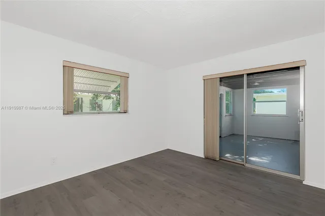 an empty room with wooden floor and mirror