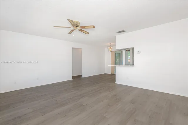 a view of a big room with wooden floor closet and windows