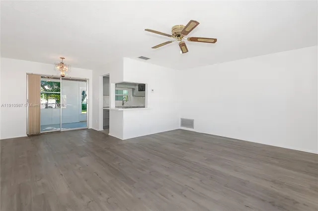 an empty room with closet and windows