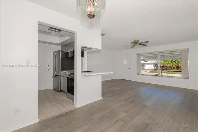 wooden floor in an empty room and a kitchen with a window