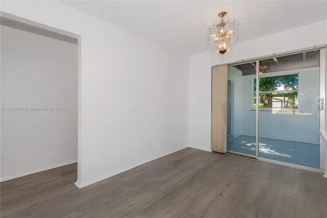 an empty room with wooden floor and window