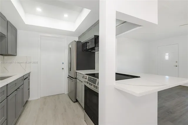 a kitchen with stainless steel appliances granite countertop a refrigerator and a stove