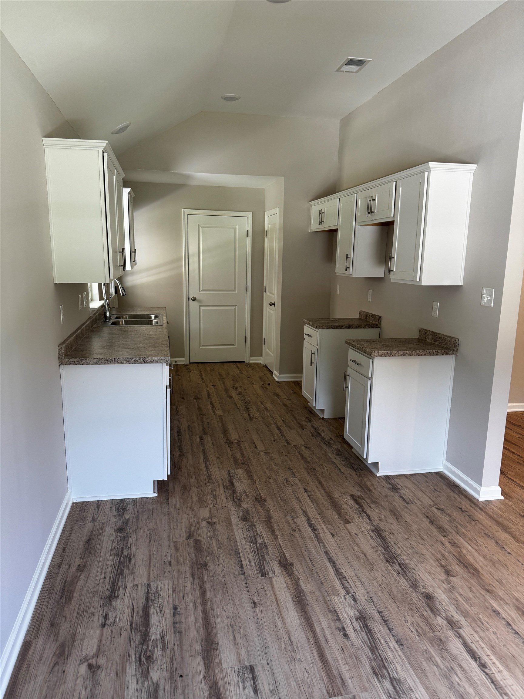 5283 Zodiac Road Memphis, TN 38118 - Photo 2 of 13 Kitchen featuring wood-finish flooring, white cabinetry, speckled countertops, and a stainless steel sink