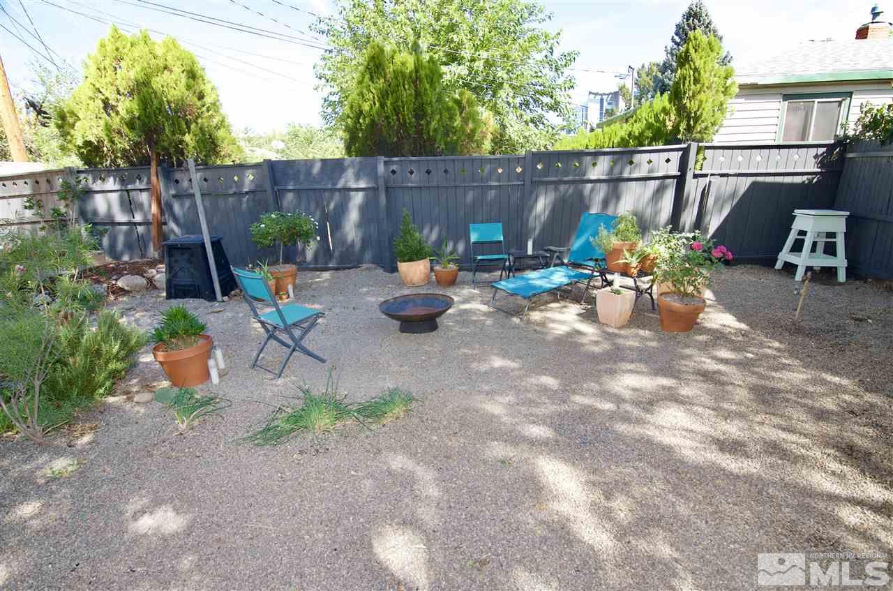 445 Ballentyne Way Reno, NV 89502 - Photo 3 of 25 a view of a backyard with chairs potted plants and wooden fence