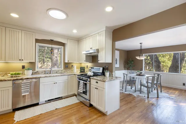 a kitchen with white cabinets and stainless steel appliances