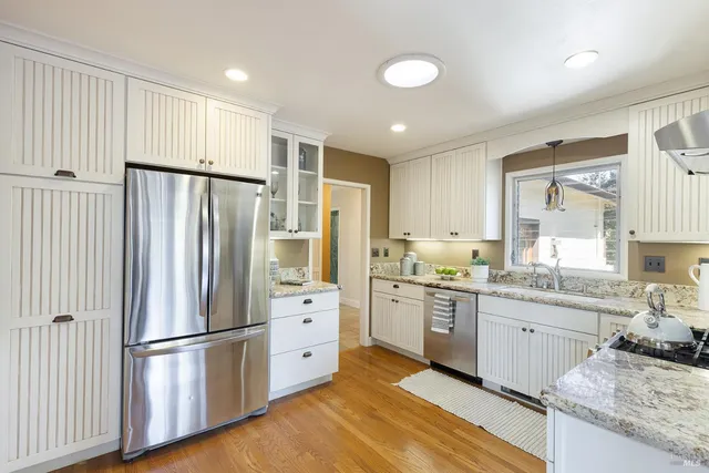 a kitchen with stainless steel appliances granite countertop a refrigerator and a stove top oven