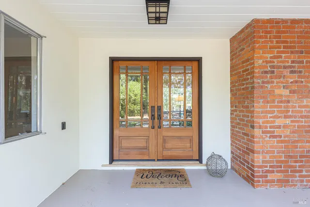 a view of a house with a yard and potted plants