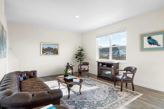 a living room with furniture a dining table and a large window