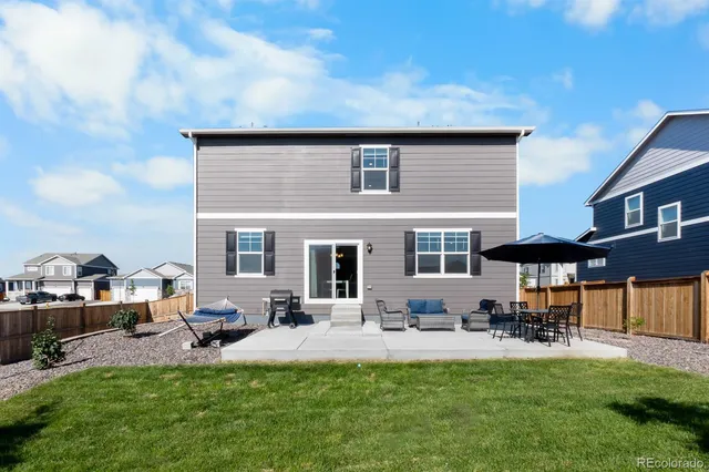 a view of a house with backyard and sitting area