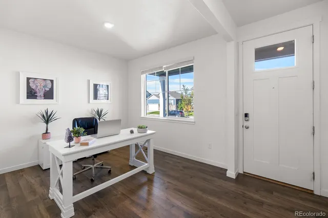 a view of a workspace with furniture and window