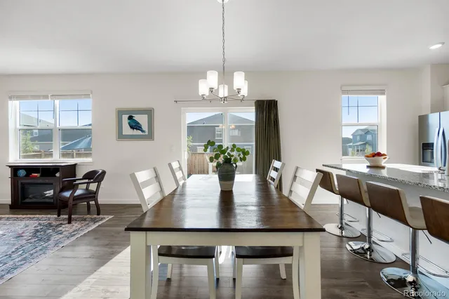 a kitchen with stainless steel appliances granite countertop a stove a sink a microwave a refrigerator and white cabinets