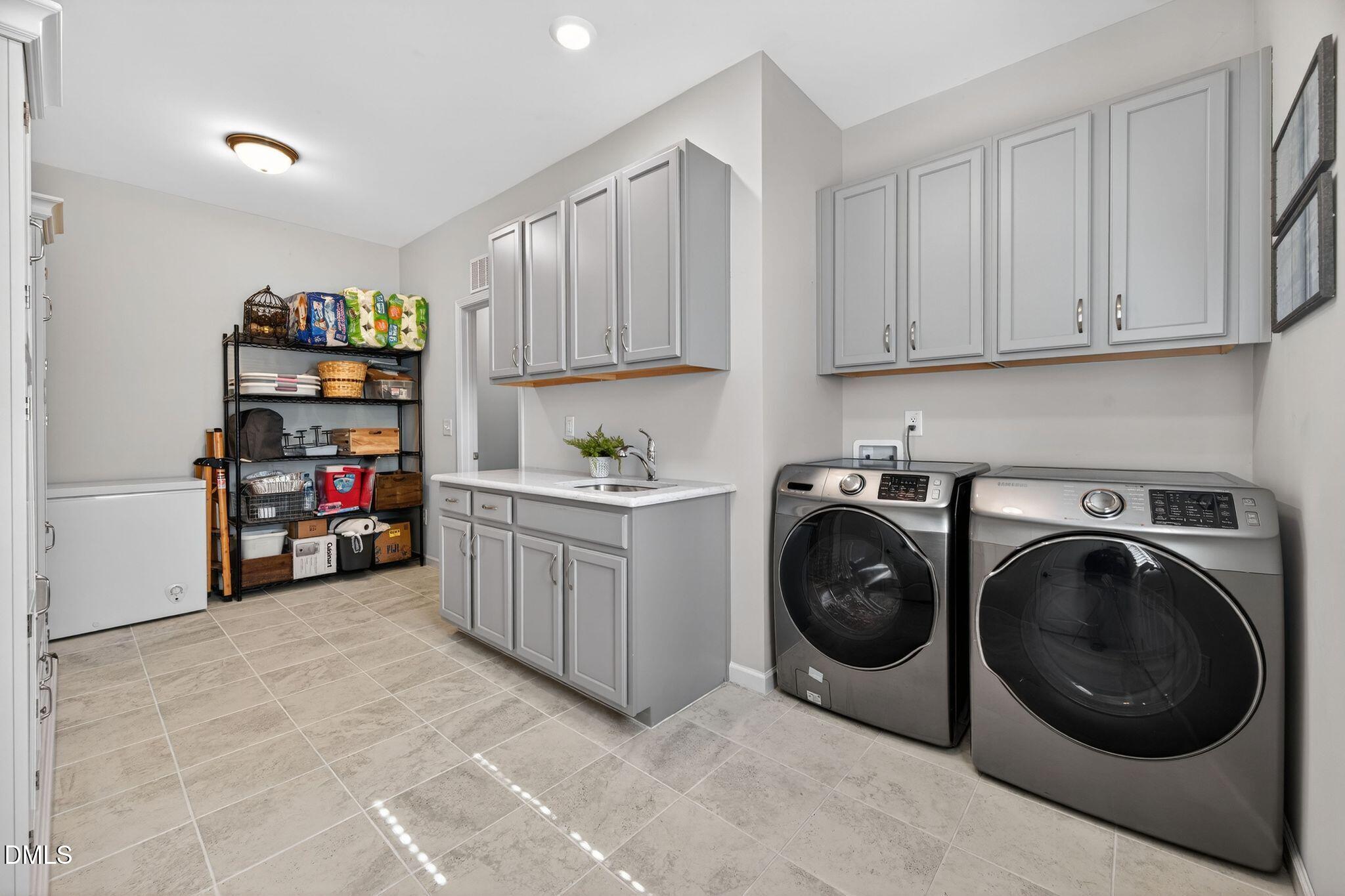 528 Spring Flower Court Cary, NC 27511 - Photo 32 of 51 a utility room with cabinets dryer and washer