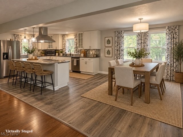 1087 Krumroy Road Akron, OH 44306 - Photo 16 of 38 Open concept kitchen with a large central island, stainless steel appliances, white cabinetry, and wood-finish flooring