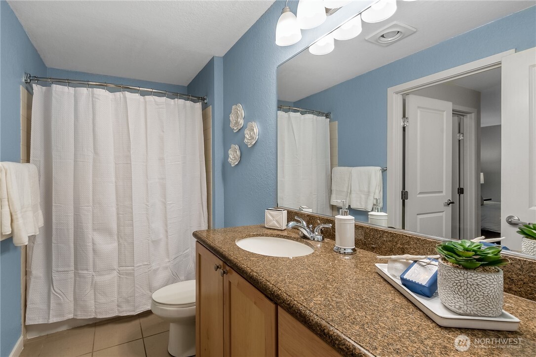 1311 12th Avenue South, Unit D202 Seattle, WA 98144 - Photo 17 of 20 a bathroom with a granite countertop sink and a mirror
