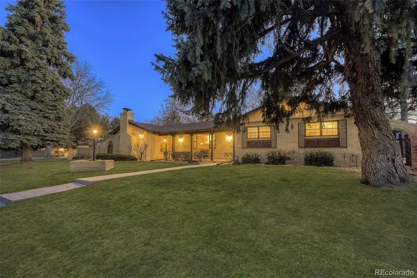 a view of a house with a big yard and large trees